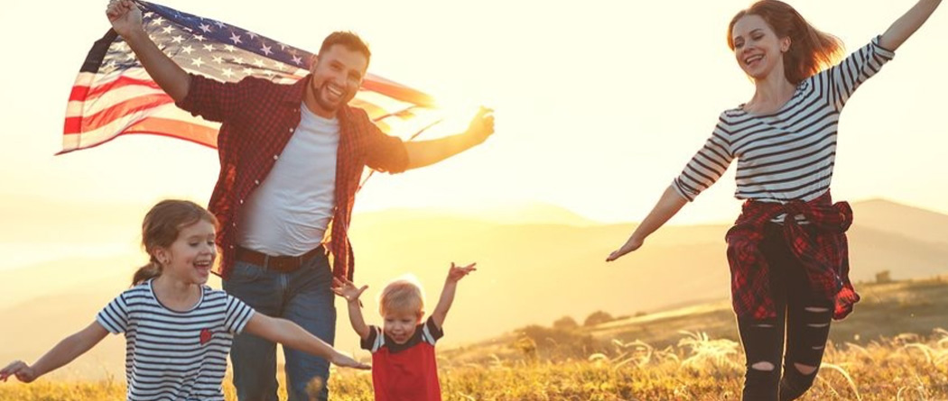 Family running with an american flag.