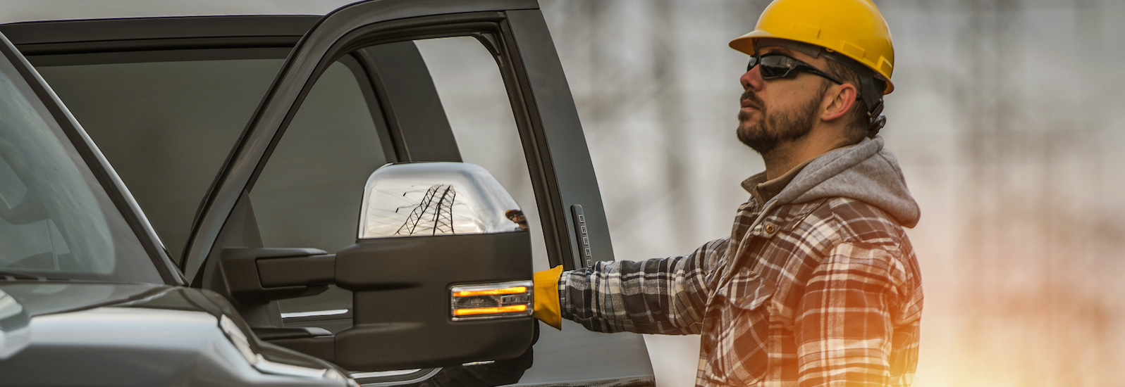 man in hard hat standing outside pickup truck