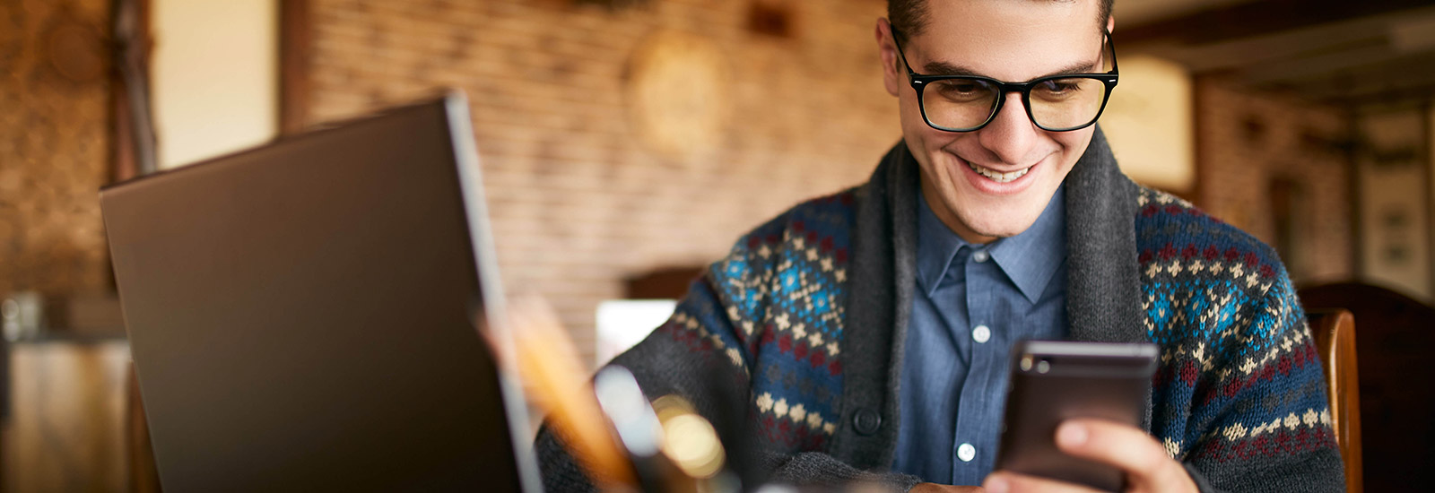 Young man using phone in restaurant