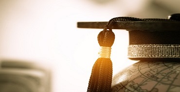 graduation cap with tassel sitting on globe
