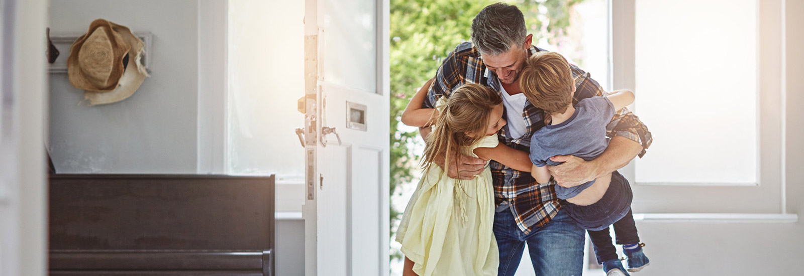 Father greeting his  son and daughter as he comes through the door