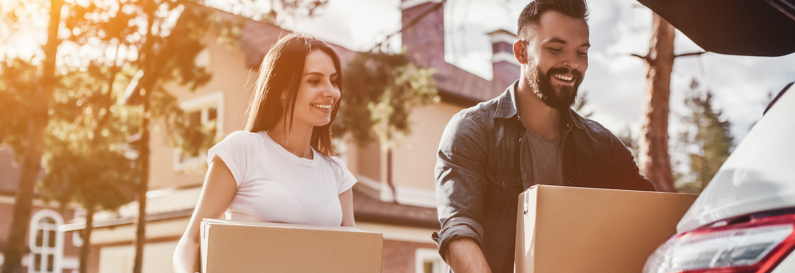 man and women loading vehicle with moving boxes