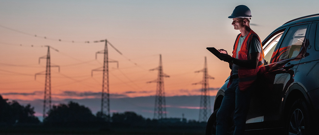 Energy worker using a tablet at sunset.