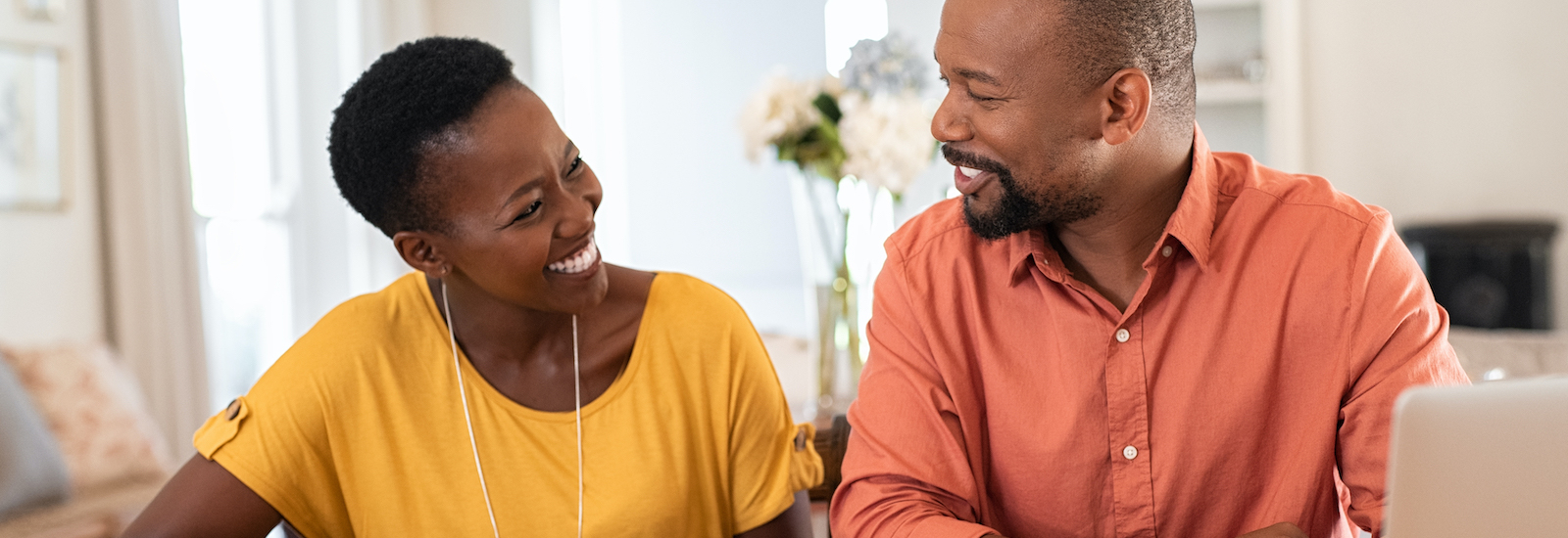 man and women looking at computer smiling at each other