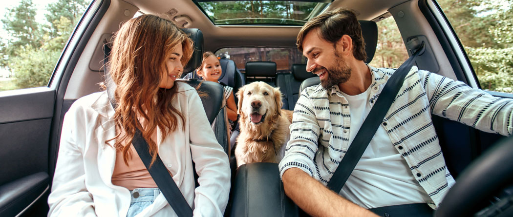 Family in the car with their dog.