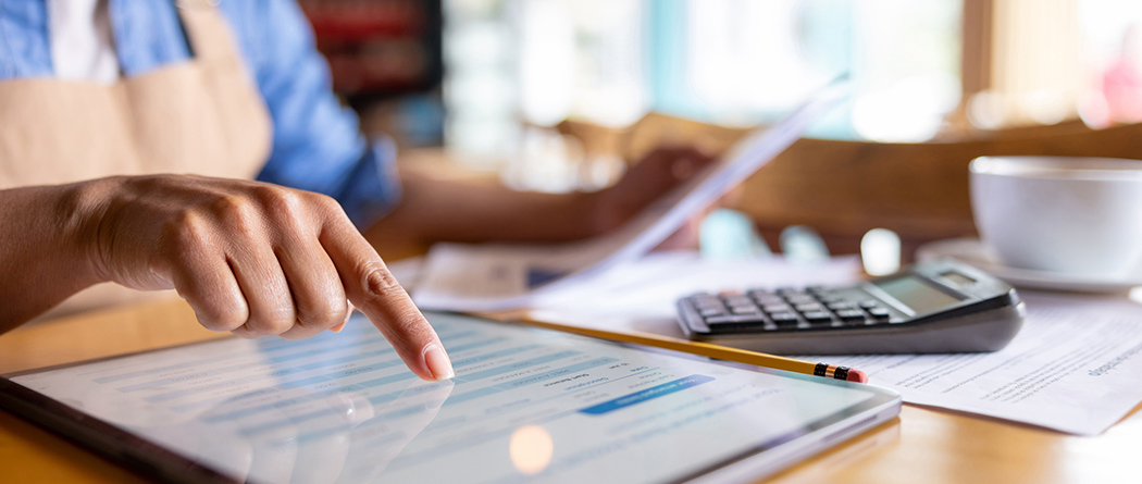 Person doing finances on a tablet.