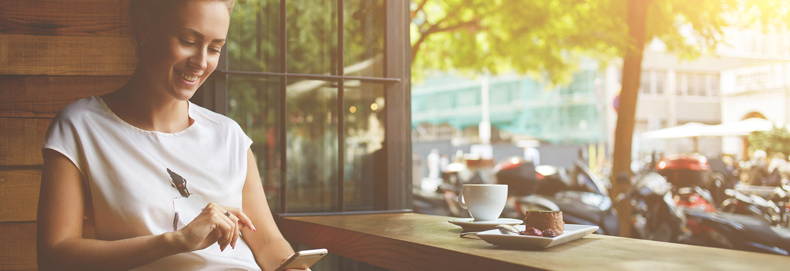 Young woman using cell phone in coffee shop